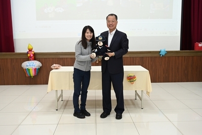 The principal presented a police teddy bear to Acting Director Ou of the Personnel Office.
